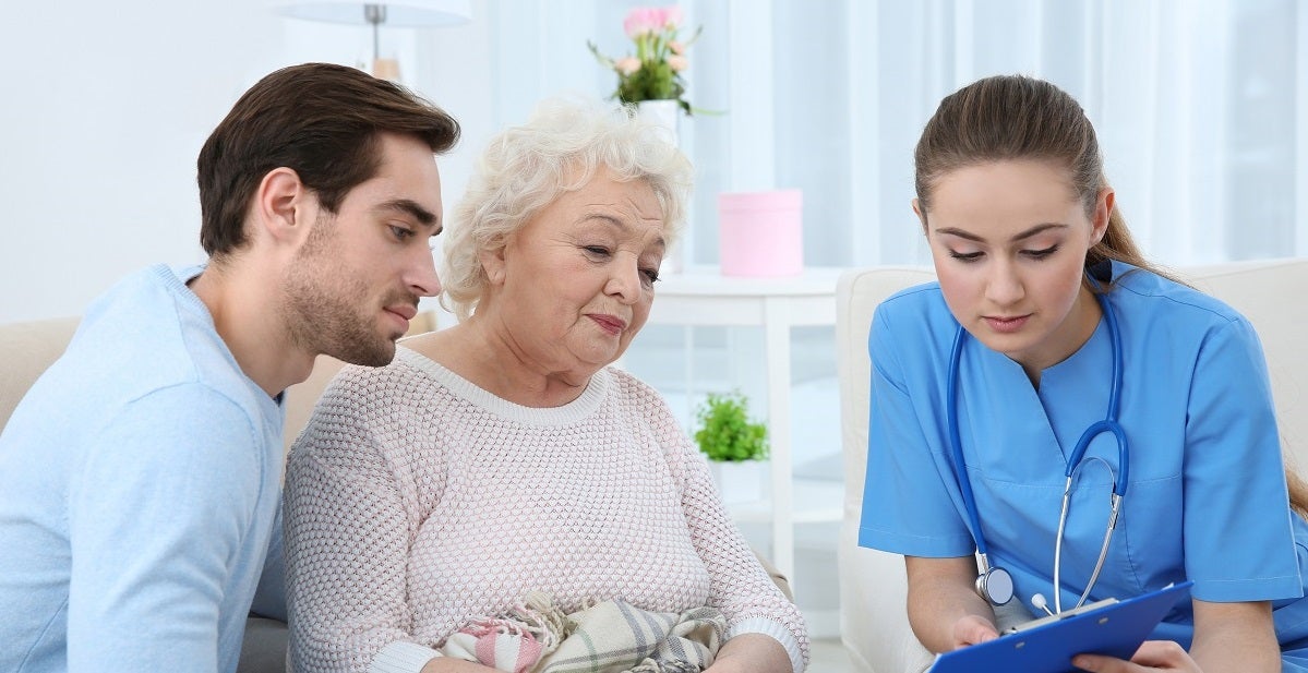 Family nurse showing test rsults to elderly female patient and her son/grandson