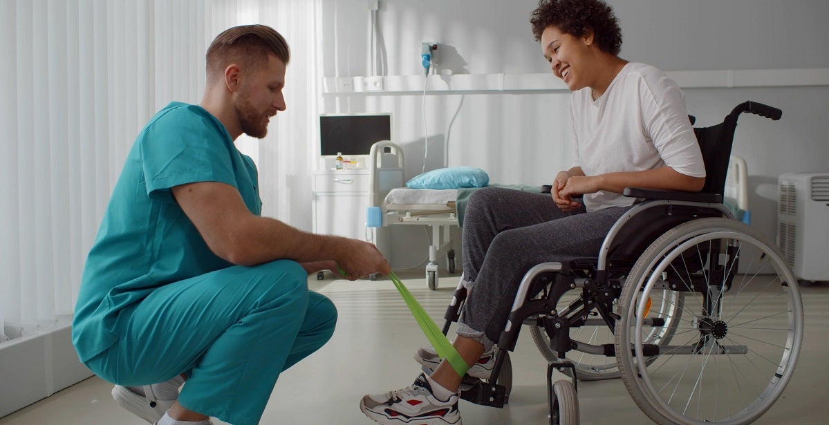  Orthopedic Nurse Practitioner supporting disabled african woman leg in wheelchair.