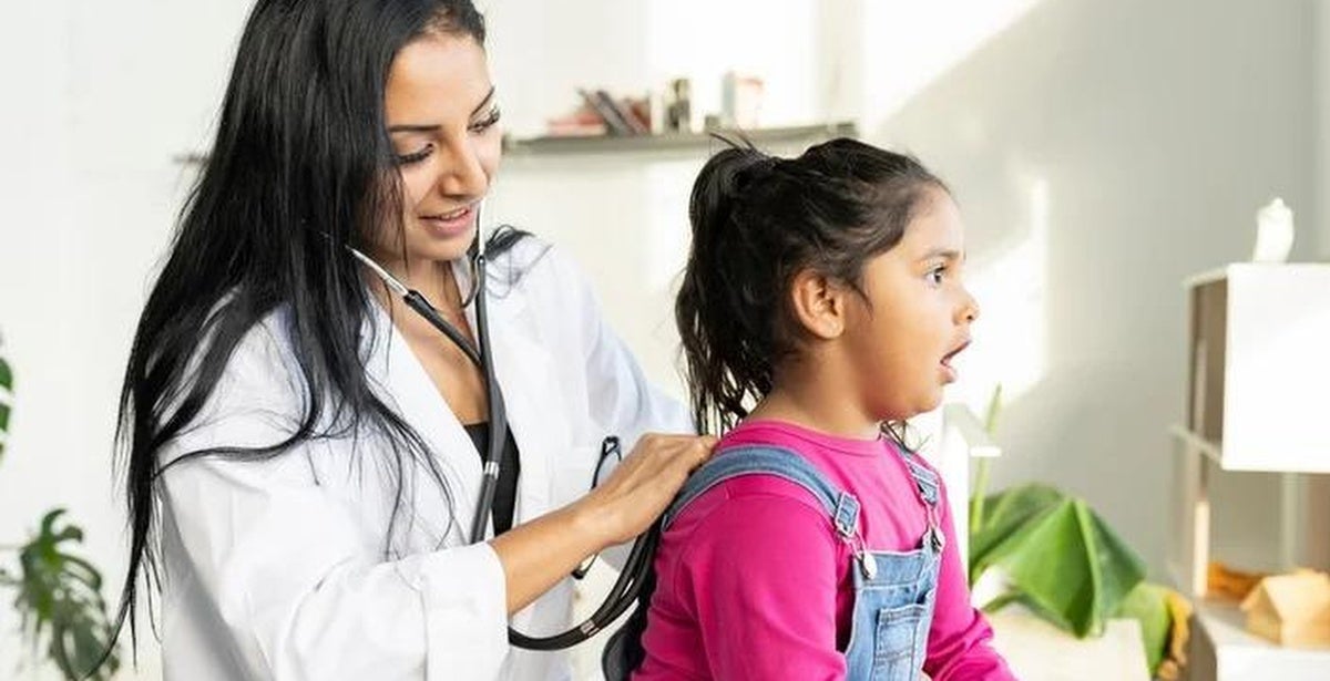 Nurse practitioner with young female patient